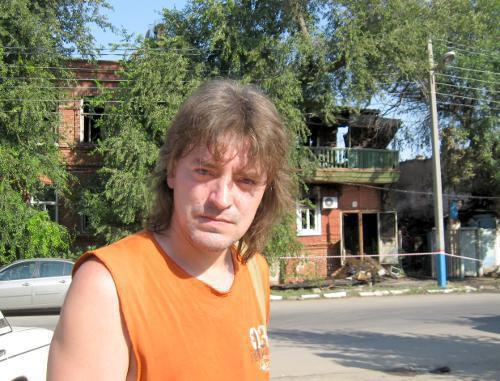 Жилец дома 28 по ул. М. Горького Александр Мурзов на фоне сгоревшего здания. Астрахань, 28 июля 2011 г. Фото "Кавказского узла"