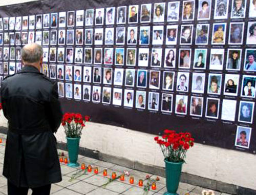 У плаката с фотографиями погибших заложников. Фото Yuri Timofeyev (RFE/RL)