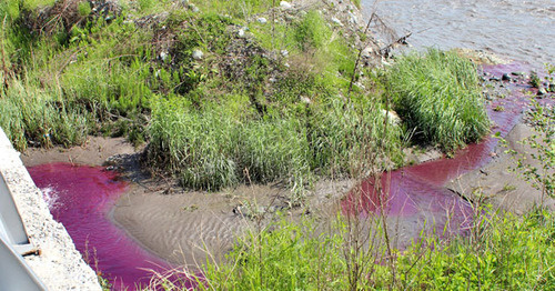 Сиреневая вода выливалась из большой трубы и растворялась в большой массе речной воды. Фото Эммы Марзоевой для "Кавказского узла" 