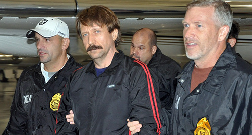 Виктор Бут в сопровождении сотрудников DEA 16 ноября 2010 года после выдачи США. Фото: Drug Enforcement Administration, https://ru.wikipedia.org/wiki/Бут,_Виктор_Анатольевич#/media/File:Viktor_Bout_Extradited_to_US.jpg 
