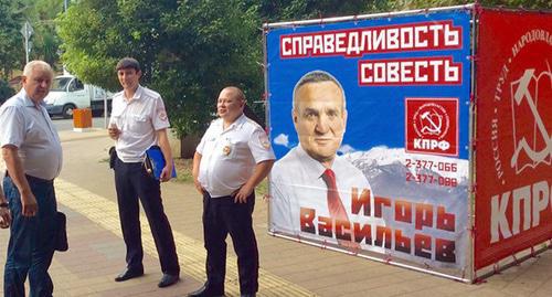 Сотрудники полиции на фоне символики КПРФ и портрета кандитата в ЗСК И. Васильева. Фото Светланы Кравченко для "Кавказского узла" Сотрудники полиции на фоне символики КПРФ и портрета кандитата в ЗСК И. Васильева. Фото Светланы Кравченко для "Кавказского узла"