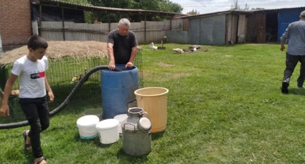 Житель ингушского села набирает воду в бочку. Фото: пресс-служба администрации Малгобекского района http://malgobek-rn.com/index.php/home/12053-2021-06-29-13-05-06.html