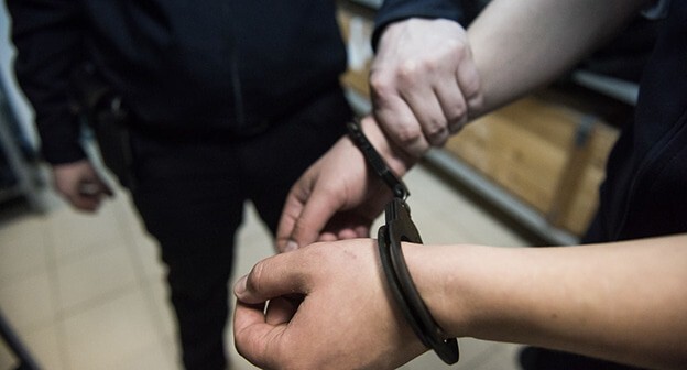 Сотрудник полиции держит за руку задержанного. Фото Елены Синеок, "Юга.ру" Сотрудник полиции держит за руку задержанного. Фото Елены Синеок, "Юга.ру"