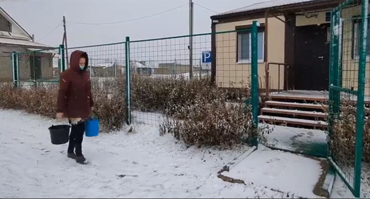 Сотрудница фельдшерско-акушерского пункта в селе Алексеевка Володарского района несет воду с улицы в медпункт. Кадр из видео https://vk.com/wall-37473293_1852371 Сотрудница фельдшерско-акушерского пункта в селе Алексеевка Володарского района несет воду с улицы в медпункт. Кадр из видео https://vk.com/wall-37473293_1852371