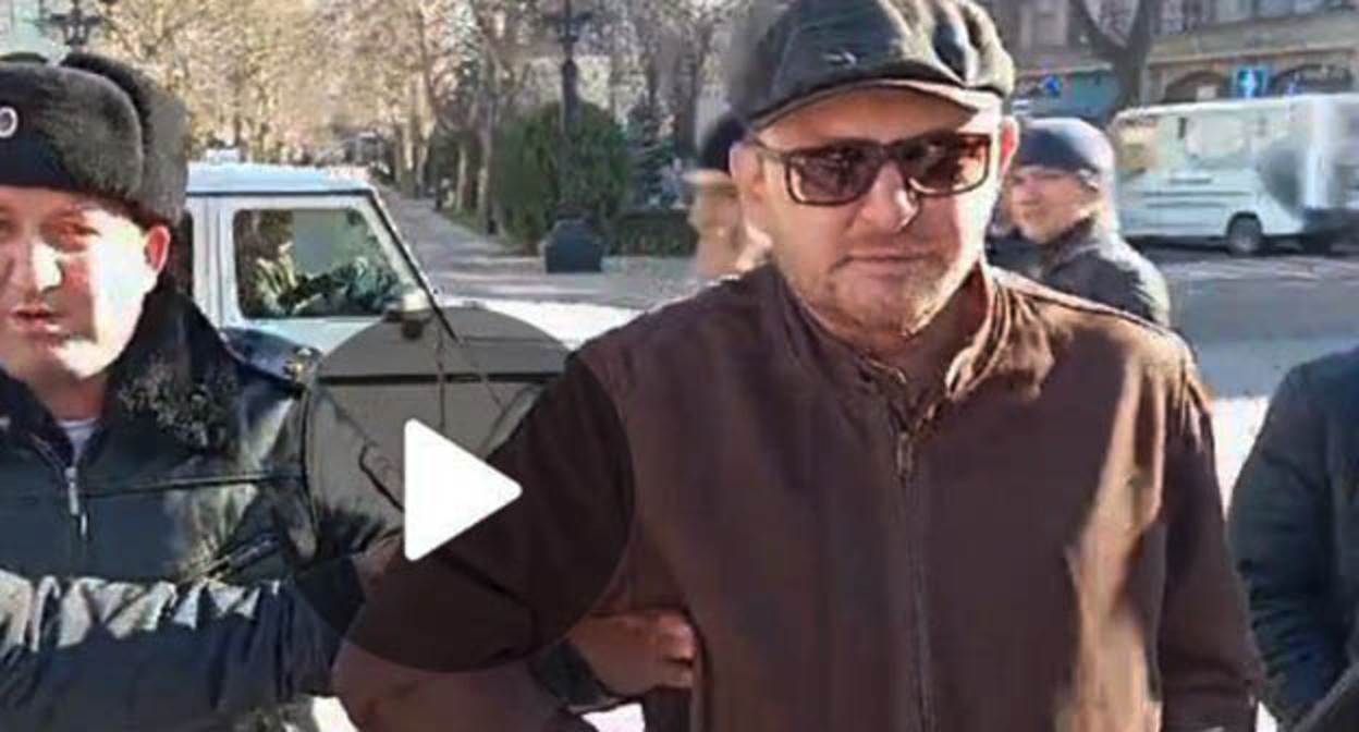 Человек, задержанный вместе с Магомедом Магомедовым во время проведения одиночного пикета в поддержку журналиста Абдулмумина Гаджиева. Махачкала, 15 января 2024 г. Скриншот видео Телеграм-канала "Черновик" Человек, задержанный вместе с Магомедом Магомедовым во время проведения одиночного пикета в поддержку журналиста Абдулмумина Гаджиева. Махачкала, 15 января 2024 г. Скриншот видео Телеграм-канала "Черновик"