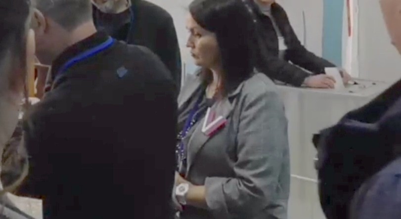 Женщина опускает листы бумаги в избирательную урну. Кадр видео из телеграм-канала Станислава Андрейчука https://t.me/sandreychuk/474 Женщина опускает листы бумаги в избирательную урну. Кадр видео из телеграм-канала Станислава Андрейчука https://t.me/sandreychuk/474