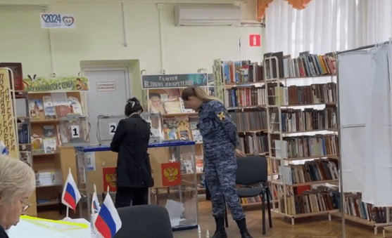 Сотрудница Росгвардии на участке в Краснодаре у урны с бюллетенями. Стоп-кадр видео, опубликованного 17.03.24 на сайте проекта "Карта нарушений", https://www.kartanarusheniy.org/messages Сотрудница Росгвардии на участке в Краснодаре у урны с бюллетенями. Стоп-кадр видео, опубликованного 17.03.24 на сайте проекта "Карта нарушений", https://www.kartanarusheniy.org/messages