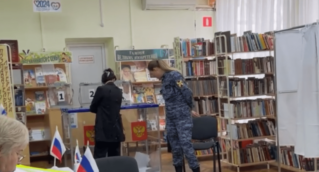 Сотрудница Росгвардии на участке в Краснодаре у урны с бюллетенями. Стоп-кадр видео, опубликованного 17.03.24 на сайте проекта "Карта нарушений", https://www.kartanarusheniy.org/messages Сотрудница Росгвардии на участке в Краснодаре у урны с бюллетенями. Стоп-кадр видео, опубликованного 17.03.24 на сайте проекта "Карта нарушений", https://www.kartanarusheniy.org/messages