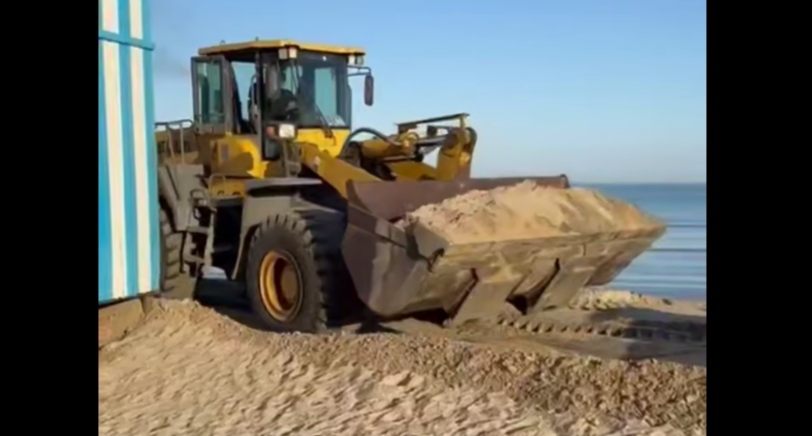 Экскаватор убирает защитный вал на пляже в Анапе. Кадр видео оперштаба Краснодарского края от 05.07.25, https://t.me/opershtab23/13690