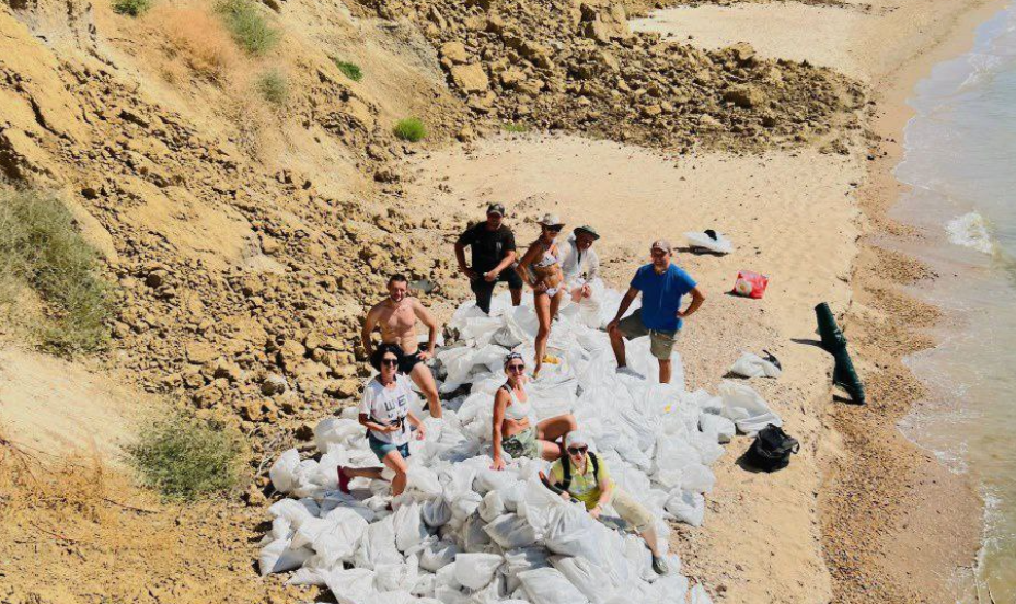 Волонтеры на фоне собранных мешков с загрязненным мазутом грунтом. Фото предоставлено "Кавказскому узлу" штабом "Дельфины"