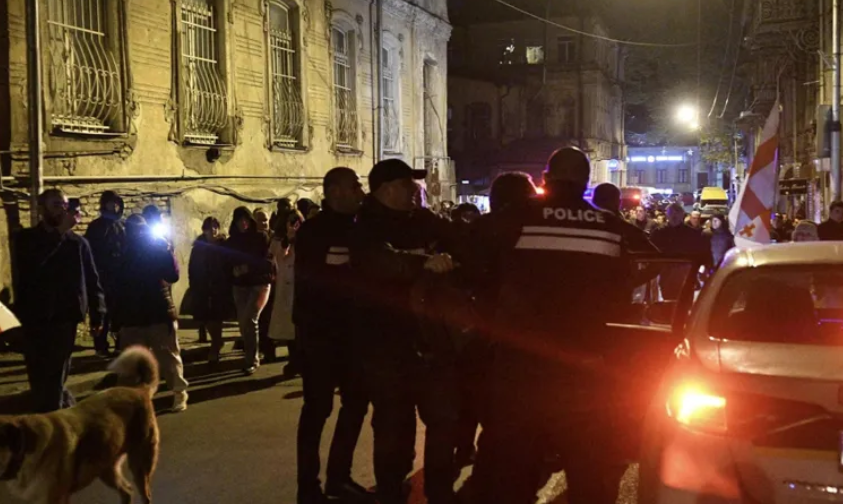 Силовики задерживают участников шествия. Скриншот фото "Интерпрессньюс" от 22.11.25, https://www.interpressnews.ge/ka/article/855324-parlamenttan-shekrebilebi-msvlelobas-martaven-ingoroqvas-kuchastan-akciis-kidev-ramdenime-monacile-daakaves