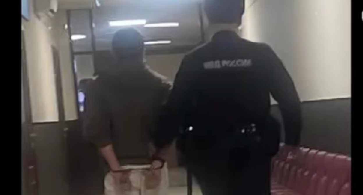 Романа Мурдиева ведут по пустому коридору суда. Стоп-кадр видео, имеющегося в распоряжении "Кавказского узла".