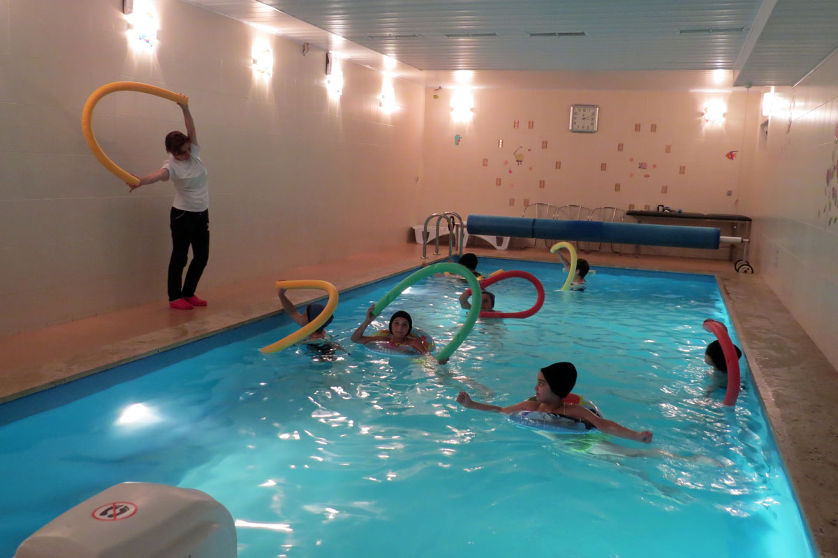 Карина Исраелян проводит упражнение на воде по укреплению врехних конечностей.