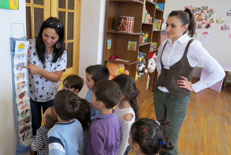 Лена показывает, а детишки говорят, что означает каждый рисунок. Они, дети, знают, что их ожидает в течение дня.