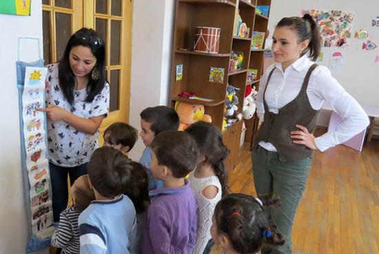 Лена показывает, а детишки говорят, что означает каждый рисунок. Они, дети, знают, что их ожидает в течение дня.