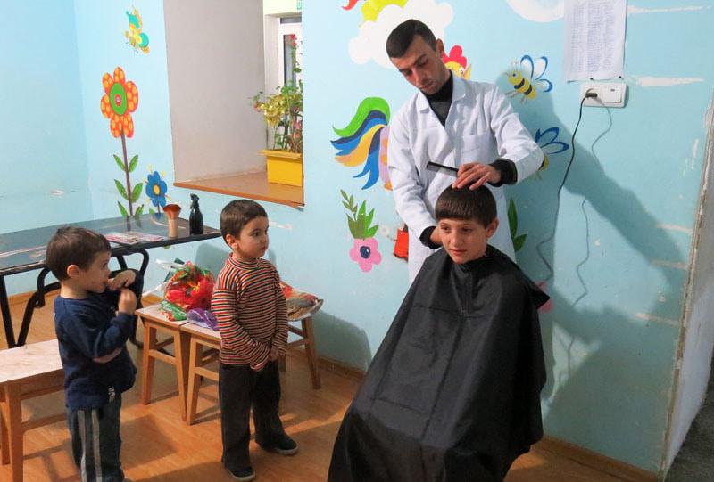 Парикмахер из салона Этуал Артур Цатурян предложил свои услуги - бесплатно постричь детей. Подошла чередь  воспитанника Саркиса.. Аренчик и Тигранчик с интересом наблюдают...